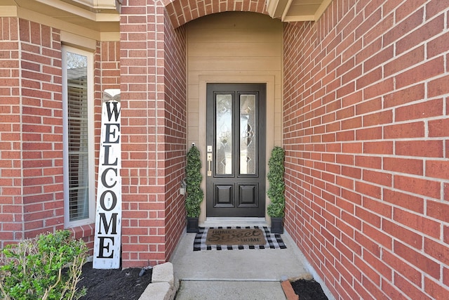 view of exterior entry with brick siding