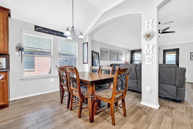 dining room featuring visible vents, light wood-style floors, an inviting chandelier, crown molding, and vaulted ceiling