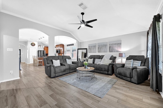 living room featuring visible vents, light wood-style flooring, a ceiling fan, arched walkways, and vaulted ceiling