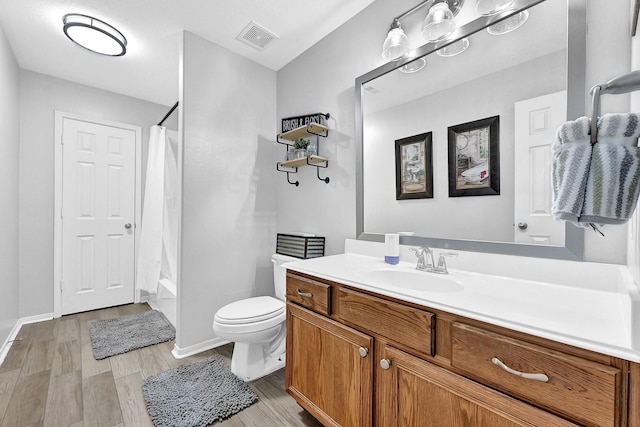 full bath featuring visible vents, shower / bath combo with shower curtain, toilet, wood finished floors, and vanity