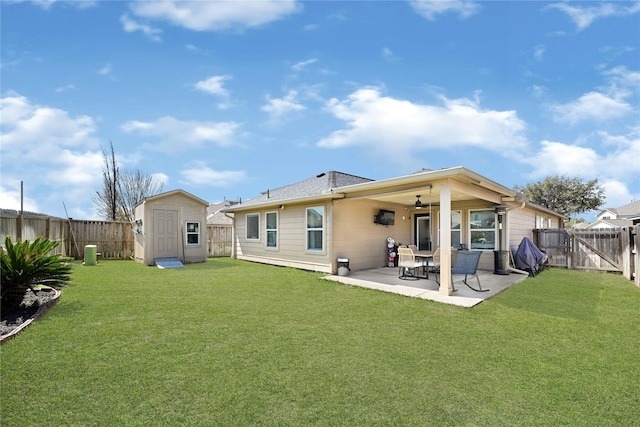 back of property with an outbuilding, a fenced backyard, a storage shed, ceiling fan, and a patio area