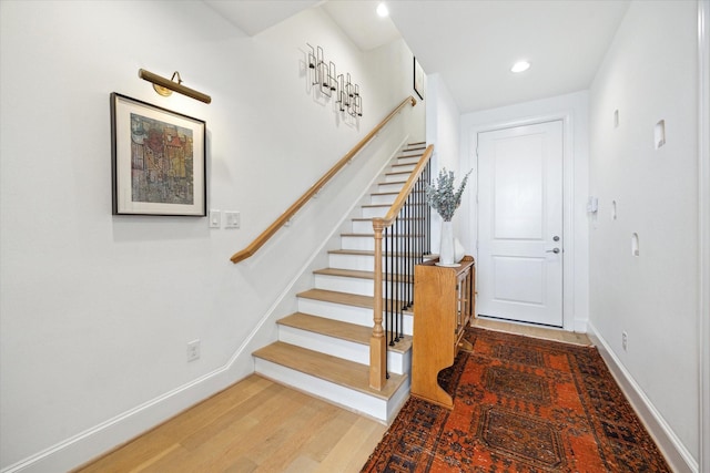 stairway with recessed lighting, wood finished floors, and baseboards