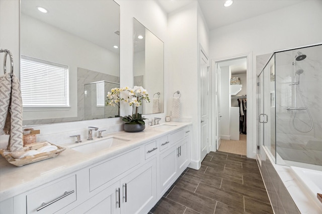 full bath featuring a shower stall, recessed lighting, double vanity, and a sink