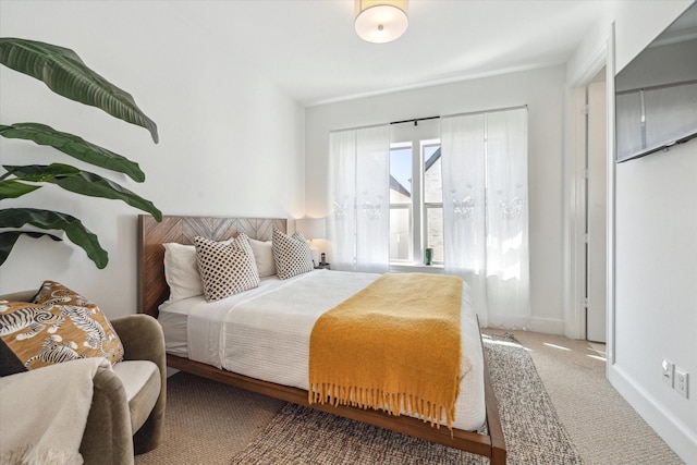 bedroom with baseboards and carpet