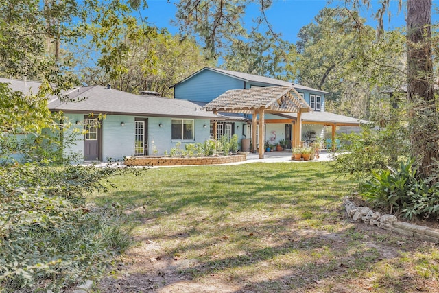 view of front of property with a front lawn, a patio area, and brick siding