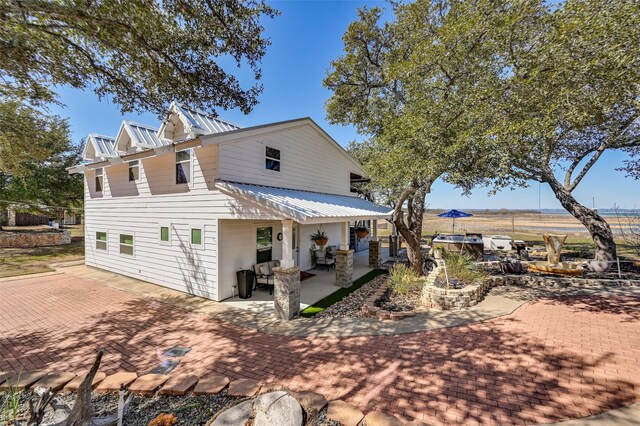 206 County Road 142, Burnet, TX 78611 - rear view of house featuring metal roof and a patio