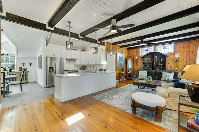 206 County Road 142, Burnet, TX 78611 - living area with light wood-style flooring, lofted ceiling with beams, wood walls, ceiling fan, and baseboards