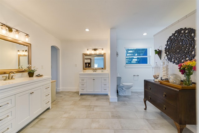 206 County Road 142, Burnet, TX 78611 - bathroom featuring toilet, recessed lighting, two vanities, a sink, and baseboards