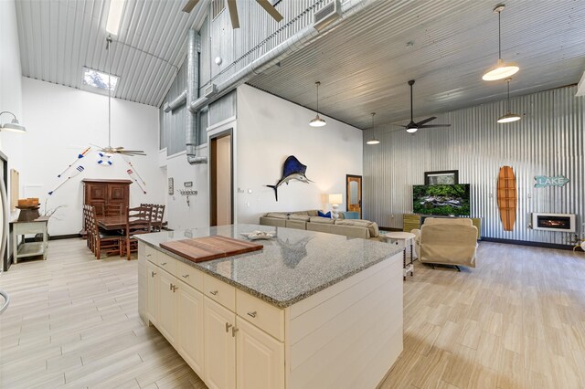 206 County Road 142, Burnet, TX 78611 - kitchen with ceiling fan, a high ceiling, light stone countertops, and a center island