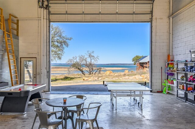 206 County Road 142, Burnet, TX 78611 - rec room with concrete flooring, a water view, a towering ceiling, and a garage