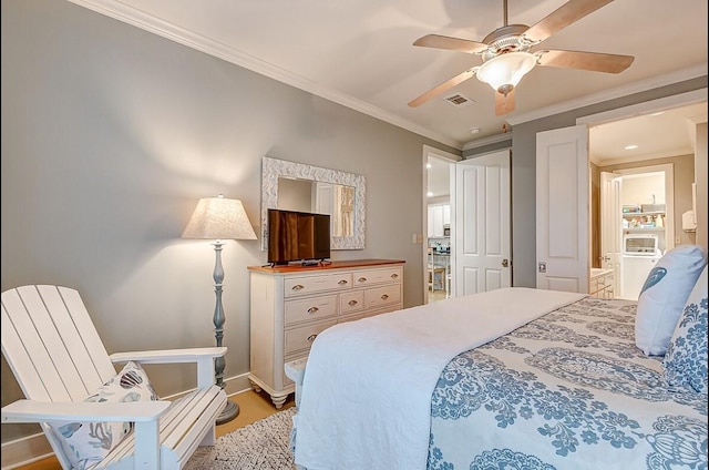 bedroom featuring visible vents, ornamental molding, ceiling fan, ensuite bath, and baseboards