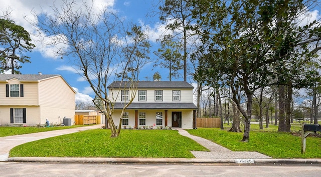 view of front of property with driveway, fence, and a front yard