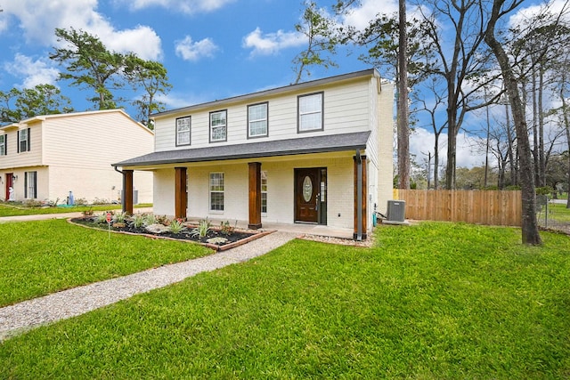 view of front of house with a porch, a front yard, brick siding, and fence