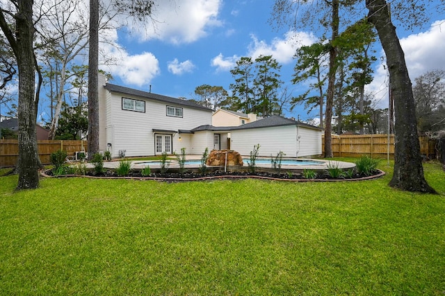 back of house with a yard, a fenced backyard, and a fenced in pool