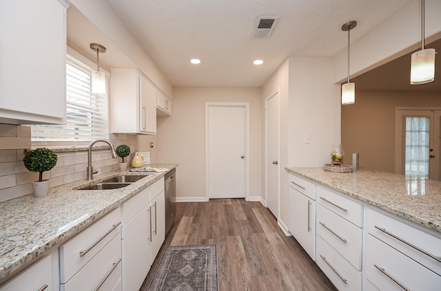 kitchen featuring a sink, visible vents, white cabinetry, a wealth of natural light, and dishwasher