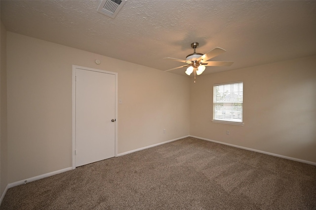 empty room with carpet, visible vents, ceiling fan, a textured ceiling, and baseboards