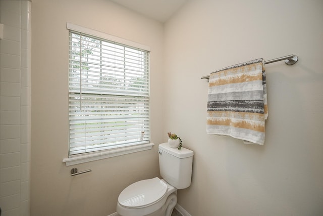 bathroom with toilet, baseboards, and a wealth of natural light