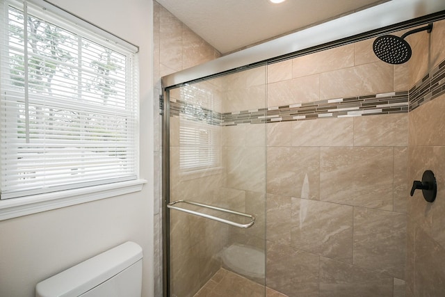 bathroom with a stall shower and toilet