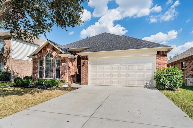 ranch-style home with brick siding, roof with shingles, an attached garage, a front yard, and driveway