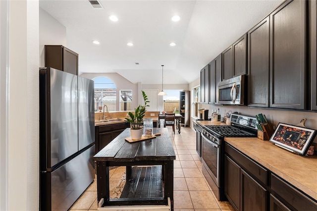 kitchen featuring appliances with stainless steel finishes, visible vents, a sink, and dark brown cabinets