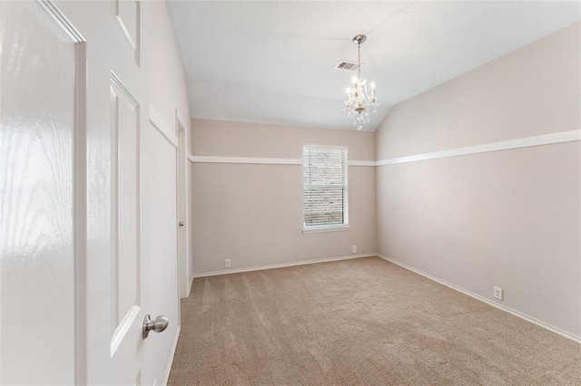 carpeted spare room with visible vents, vaulted ceiling, baseboards, and an inviting chandelier