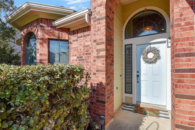 property entrance featuring brick siding