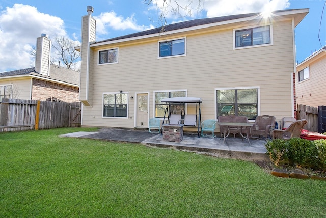 back of property with a patio area, a lawn, and a fenced backyard