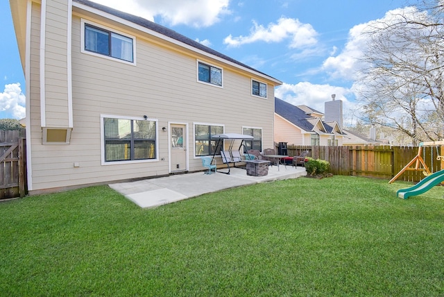 rear view of property featuring a fenced backyard, a lawn, a playground, and a patio