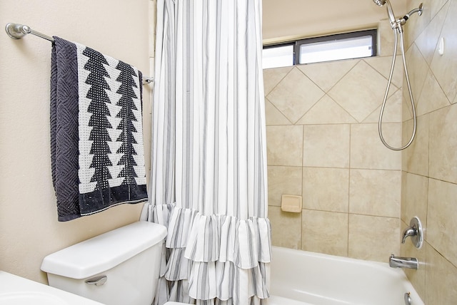 bathroom with shower / bath combination with curtain and toilet