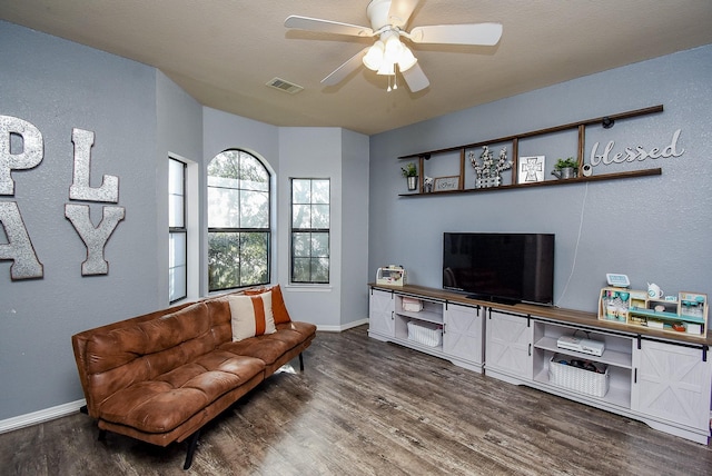 living area featuring visible vents, ceiling fan, baseboards, and wood finished floors