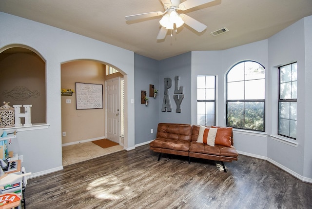 sitting room with baseboards, plenty of natural light, visible vents, and wood finished floors