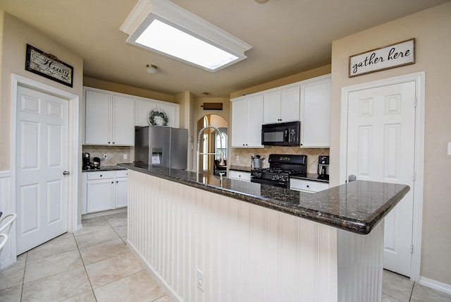 kitchen with a large island, light tile patterned floors, tasteful backsplash, white cabinetry, and black appliances