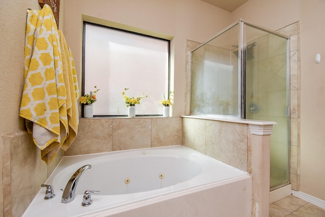 bathroom with a tub with jets, a shower stall, and tile patterned floors