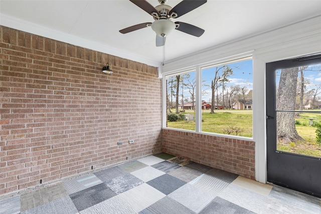 unfurnished sunroom featuring ceiling fan