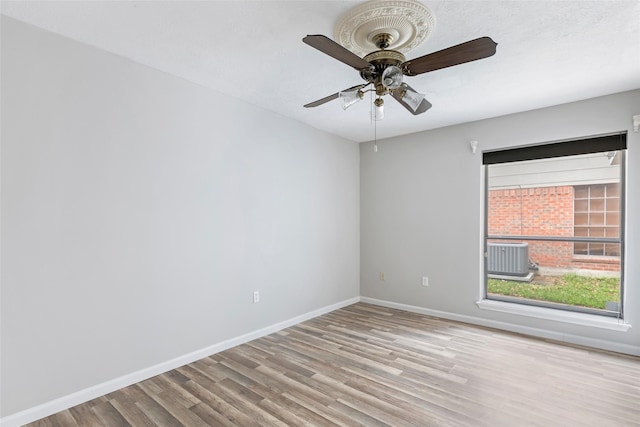 spare room featuring ceiling fan, wood finished floors, and baseboards