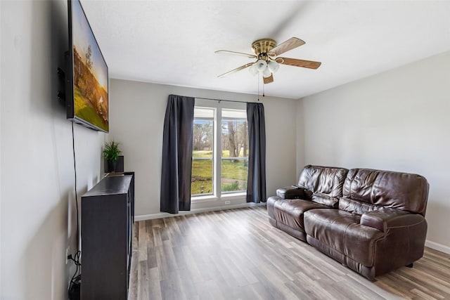 living area with ceiling fan, wood finished floors, and baseboards