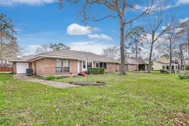 view of front of property with a front yard, brick siding, central AC, and an attached garage