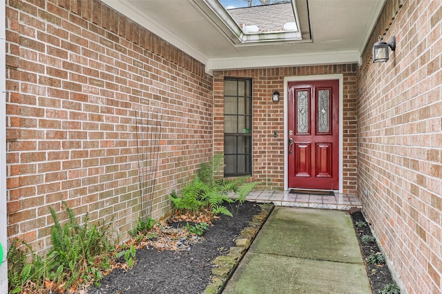 entrance to property featuring roof with shingles and brick siding