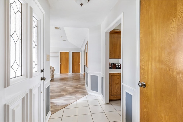 foyer entrance with light tile patterned floors and visible vents