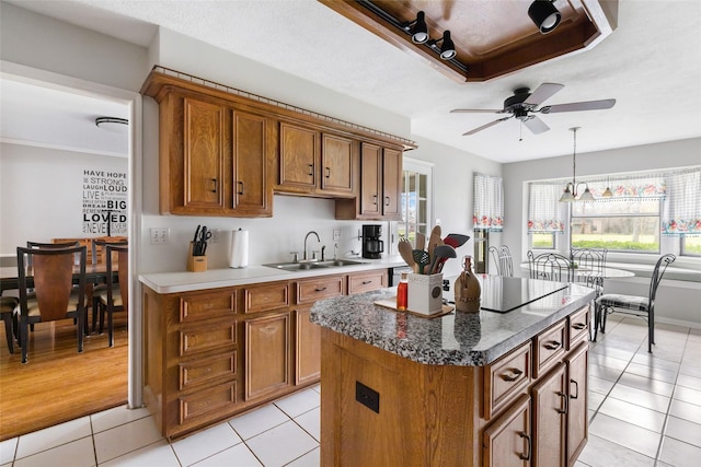 kitchen featuring a sink, black electric cooktop, and brown cabinets