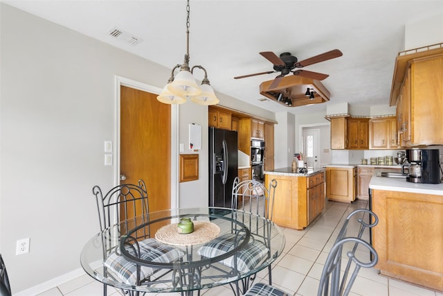 kitchen featuring light countertops, visible vents, light tile patterned flooring, a kitchen island, and black appliances