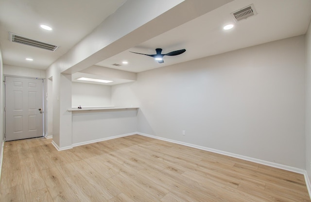 empty room with wood finished floors, visible vents, and baseboards