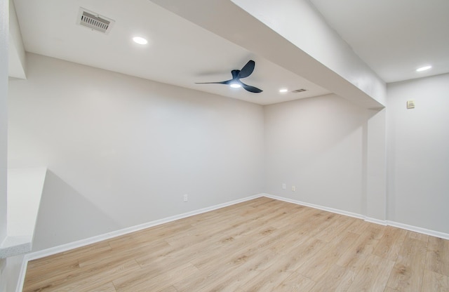 spare room featuring wood finished floors, visible vents, and baseboards