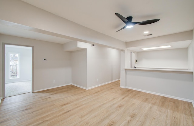 unfurnished room featuring light wood-type flooring, visible vents, and baseboards