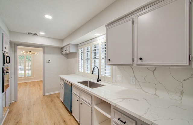 kitchen featuring light wood finished floors, stainless steel appliances, recessed lighting, visible vents, and a sink