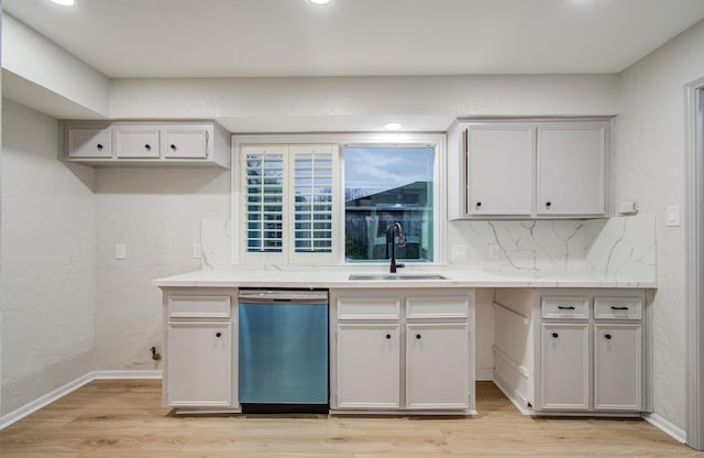 kitchen with decorative backsplash, a sink, light wood-style flooring, and dishwashing machine