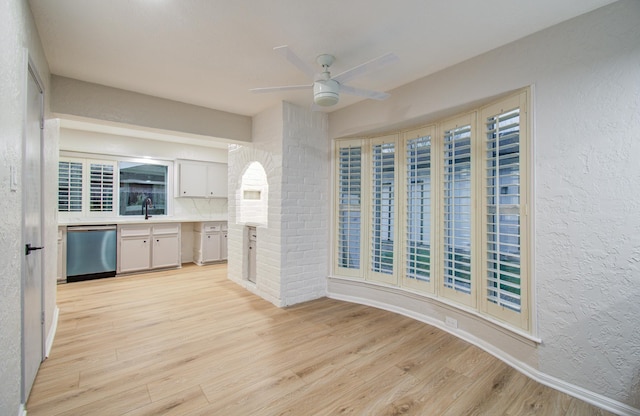 kitchen with a textured wall, dishwasher, light wood-style flooring, and ceiling fan