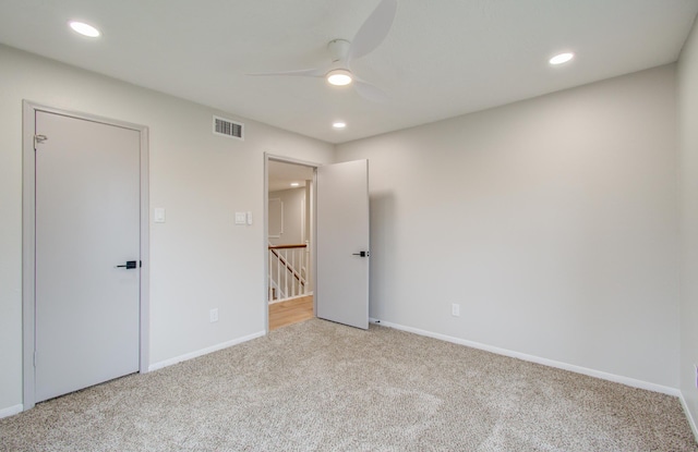 empty room with carpet floors, recessed lighting, visible vents, and baseboards