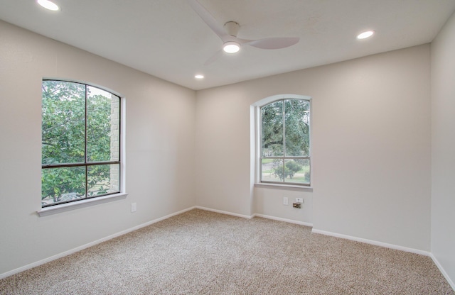 carpeted spare room with recessed lighting, ceiling fan, and baseboards