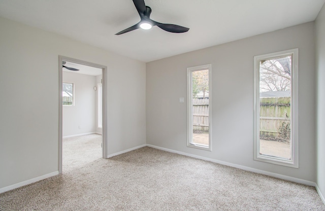 unfurnished room featuring ceiling fan, plenty of natural light, carpet flooring, and baseboards